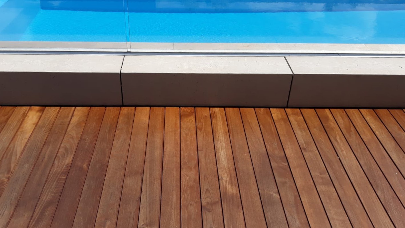 Bordo piscina in legno con acqua turchese