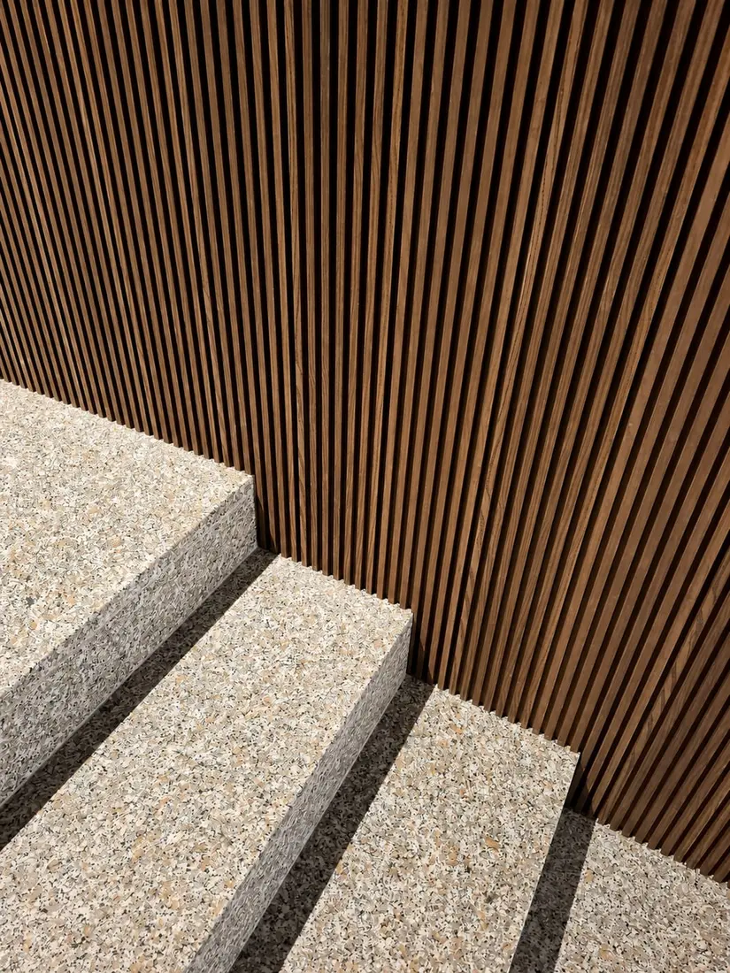 Rivestimento a doghe verticali in legno con gradini in terrazzo