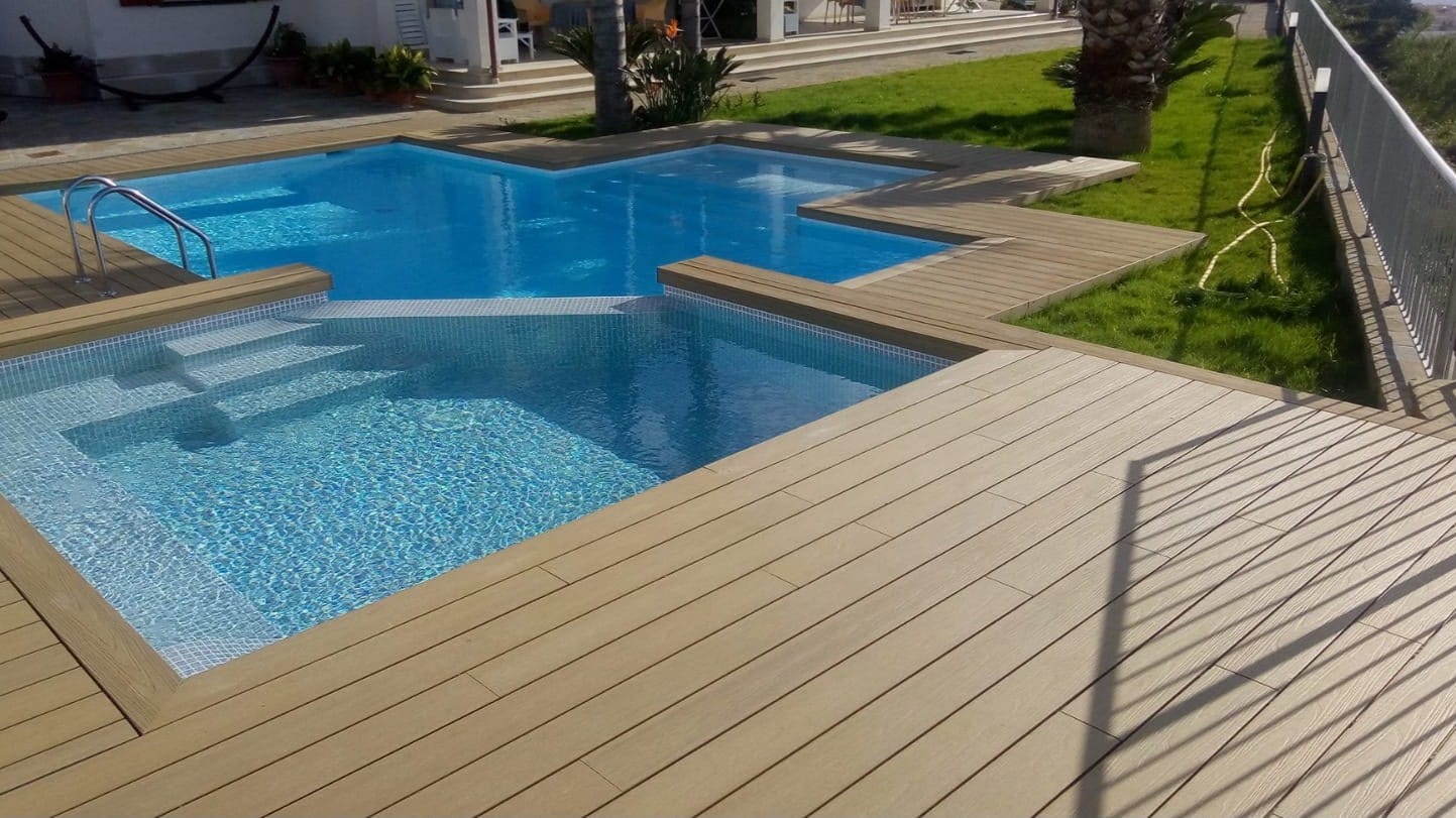 Piscina con ampio bordo in decking WPC chiaro
