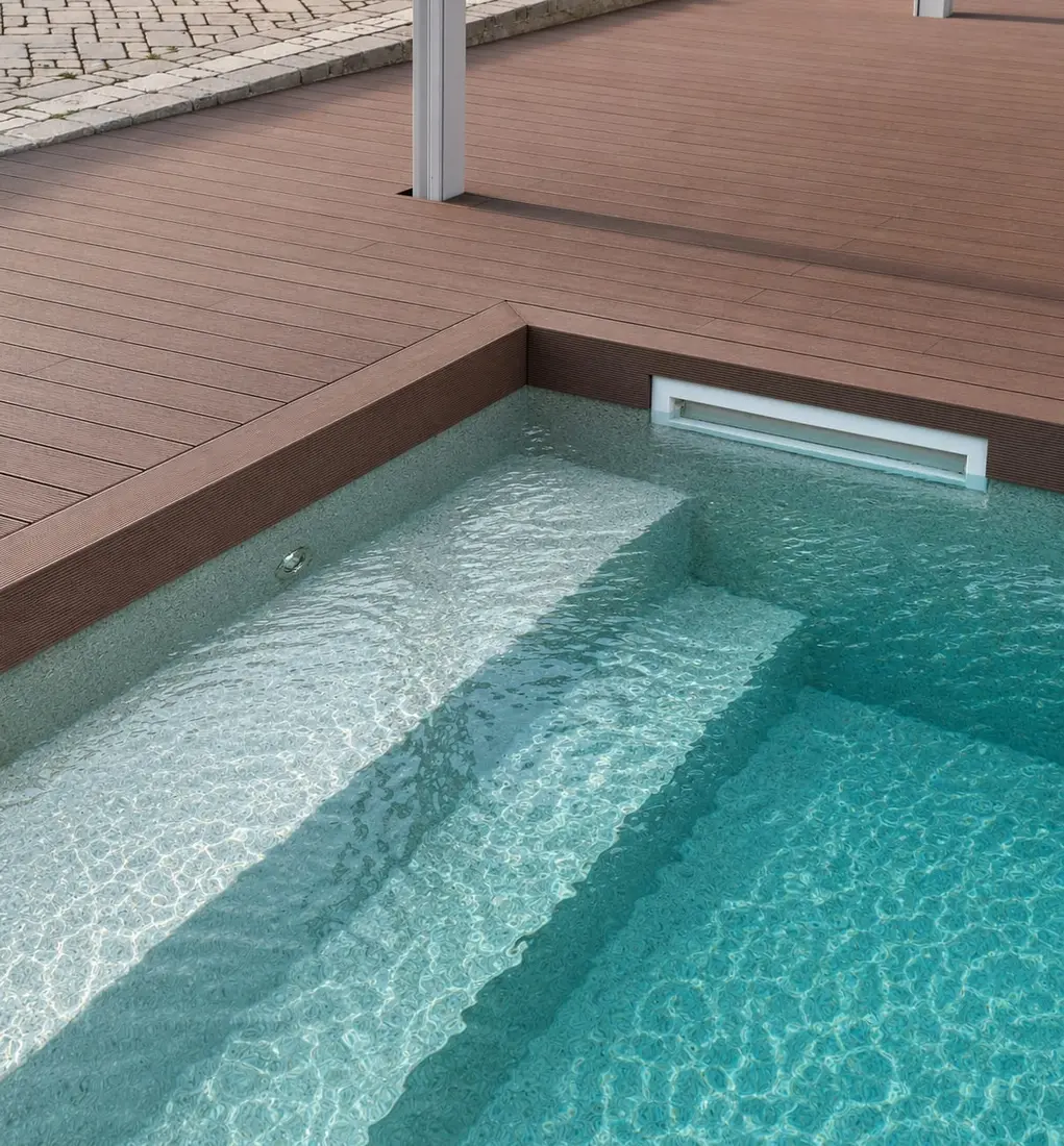 Bordo piscina in decking WPC con gradini di accesso all'acqua