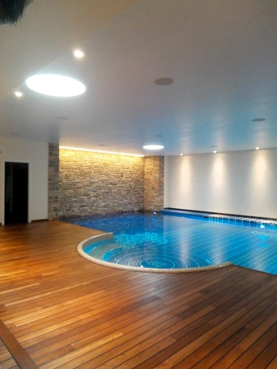 Piscina interna con bordo in teak a giunto nautico