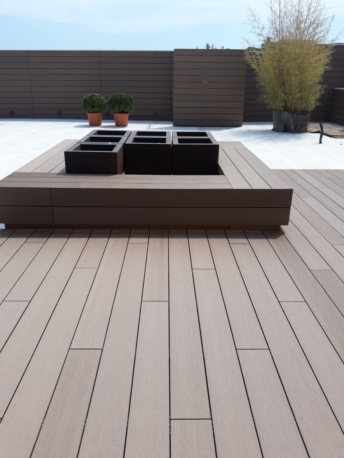 Terrazza in decking WPC con seduta e fioriere integrate